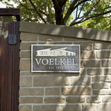 Brick wall with a sign reading 'VOELKEL Est. 2025' and an image of a house.