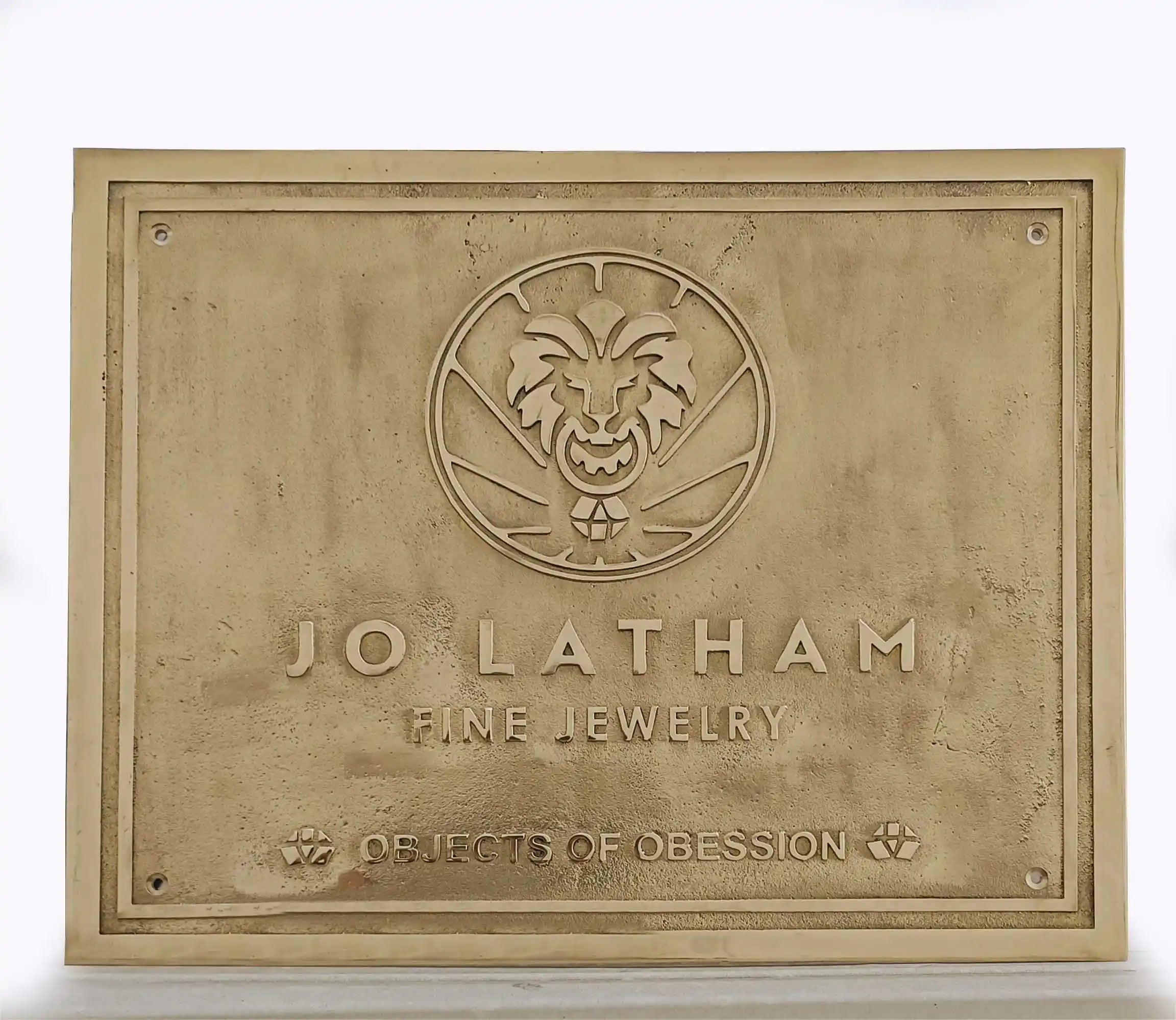 Brass plaque with 'Jo Latham Fine Jewelry' logo and text on a white background