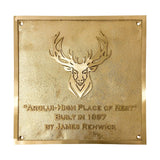Gold plaque with deer emblem and engraved text on a white background