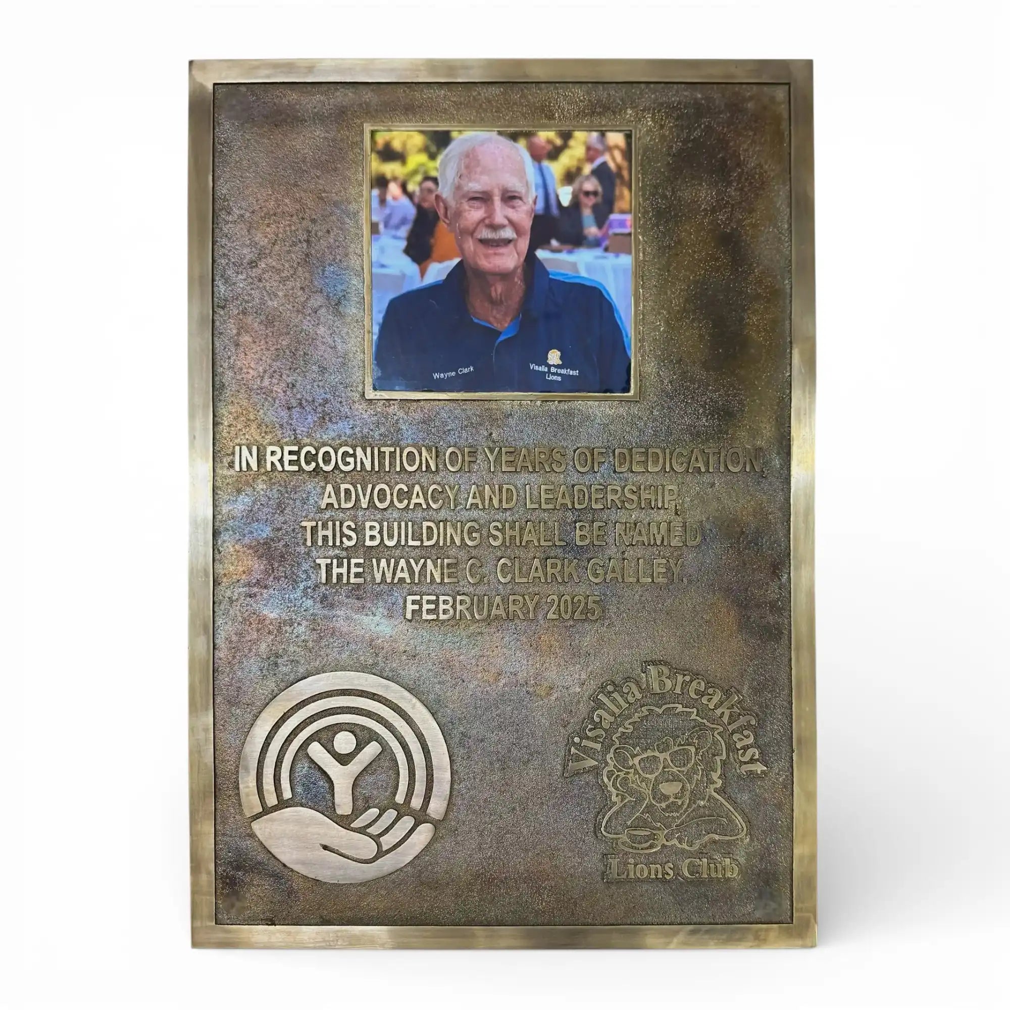Bronze plaque with engraved text and a photo of a man, on a white background