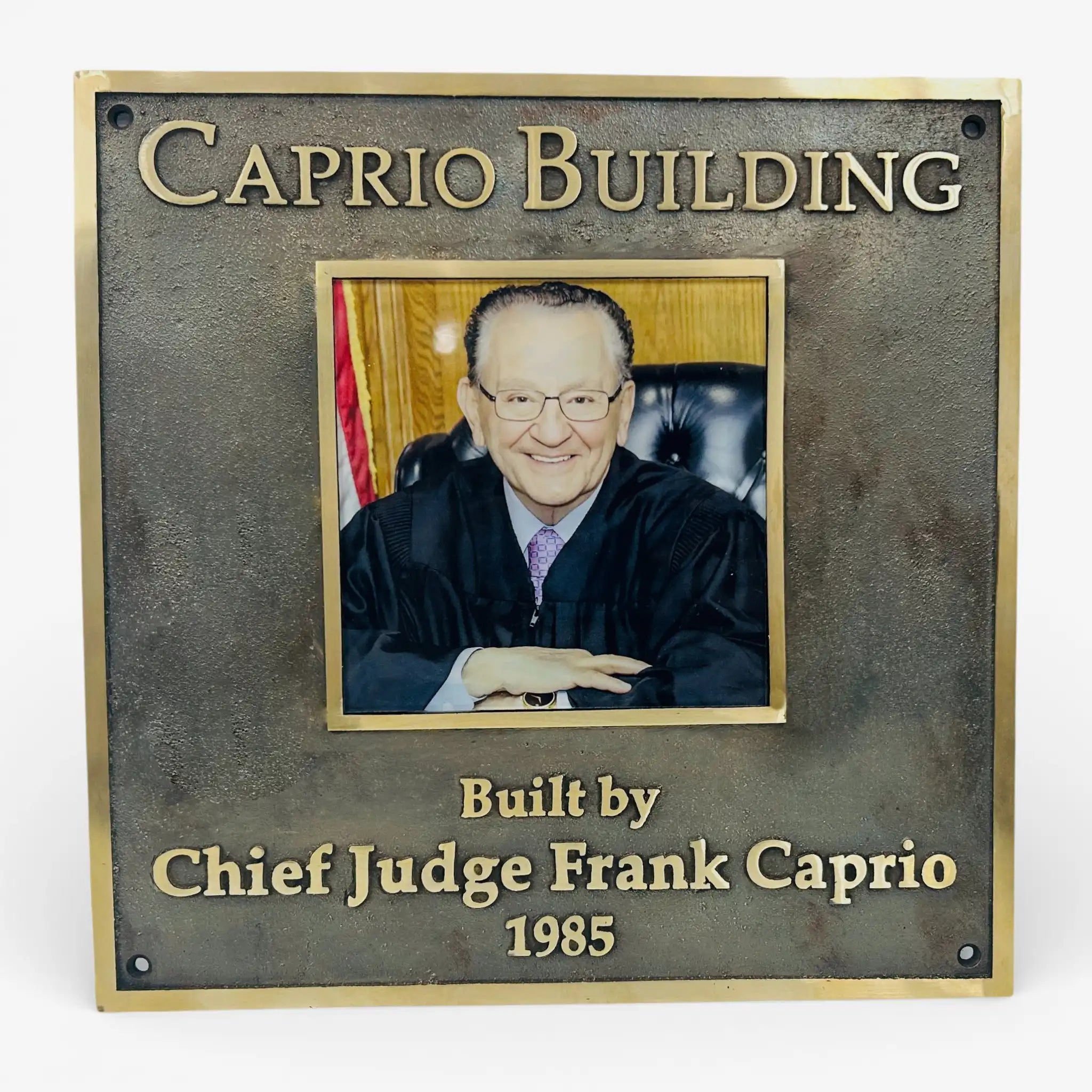 Plaque with a photo of Chief Judge Frank Caprio and text 'Caprio Building Built by Chief Judge Frank Caprio 1985'.