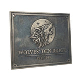 Bronze plaque with a wolf emblem and 'Wolves' Den Ridge' text on a white background