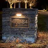 Stone wall with house number and name plaque at night