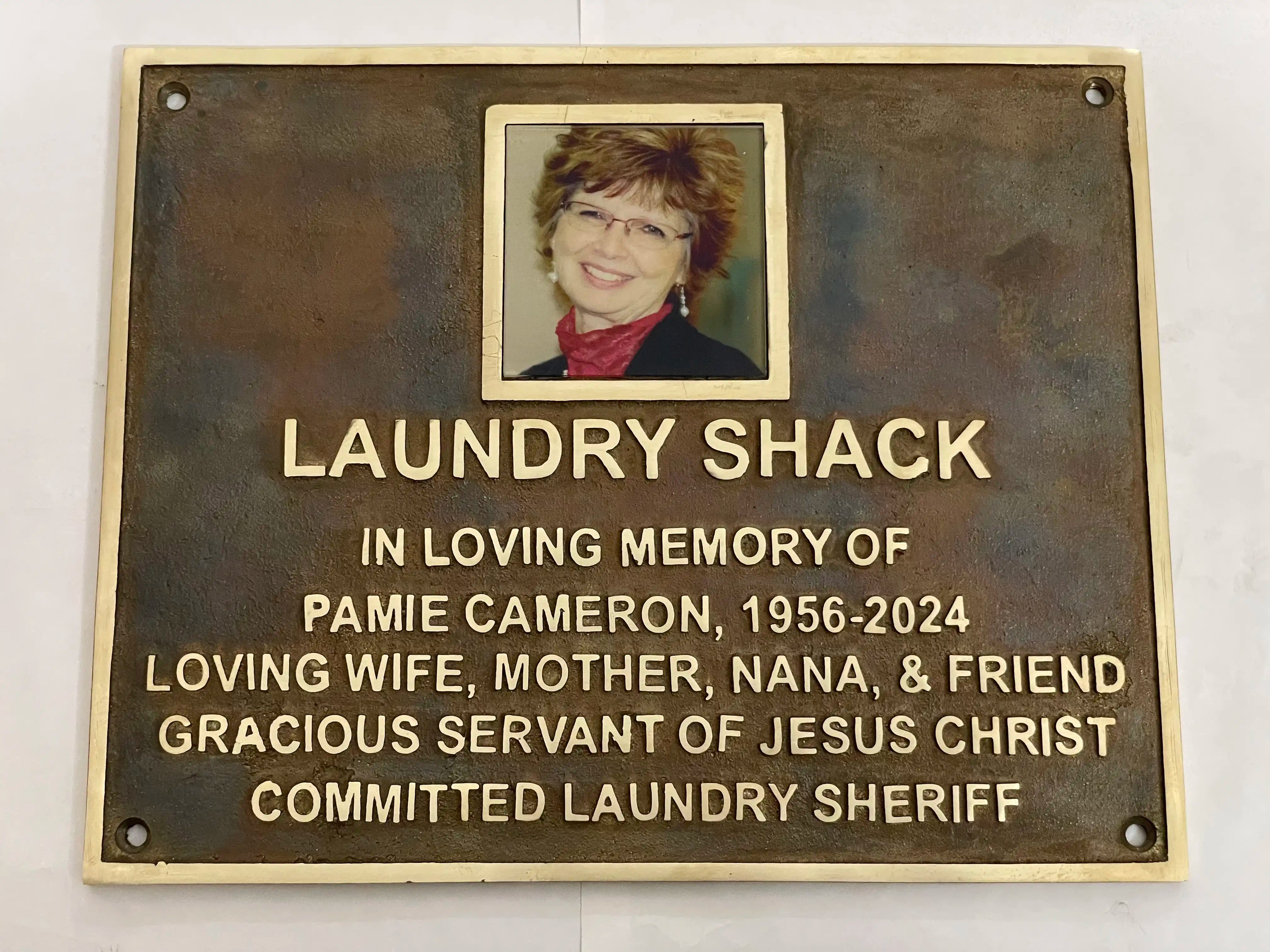 Memorial plaque for Pamie Cameron with a photo of a woman on a white background