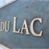 Bronze 'DU LAC' sign on a textured surface