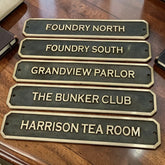 Set of decorative Bronze signs with names on a wooden surface