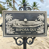 Bronze address sign with beach scene and 'Riposa Qui' text on a beach background