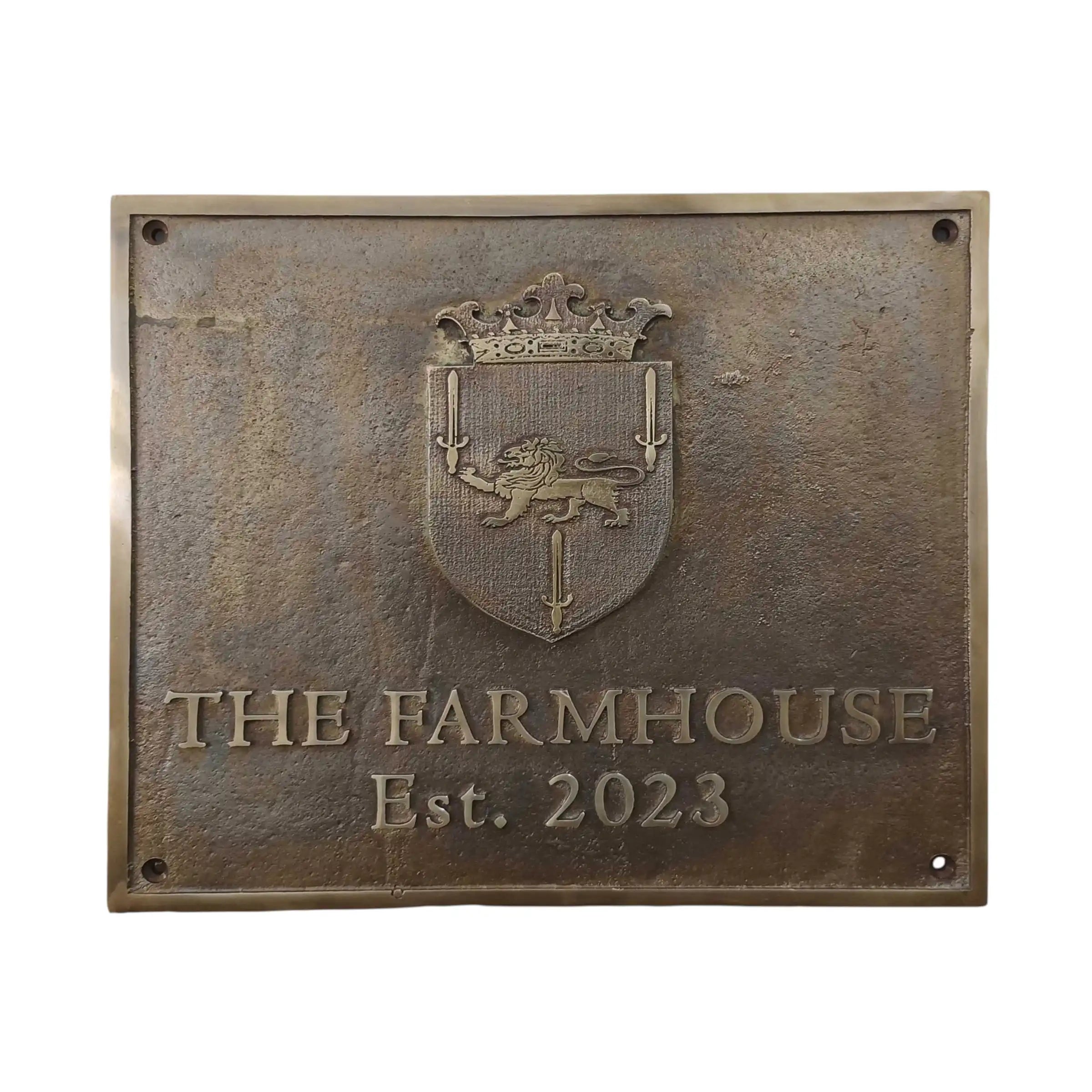 Bronze plaque with crest and 'The Farmhouse Est. 2023' text on a white background