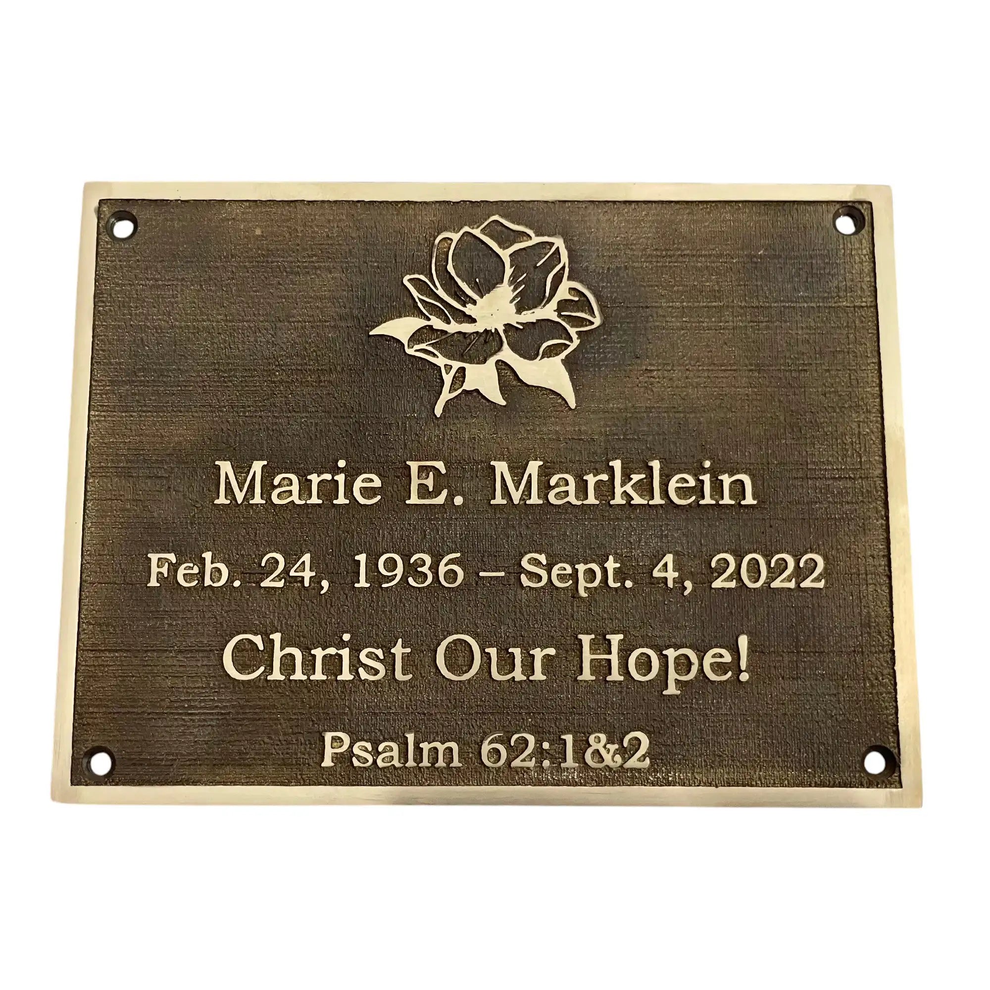 Bronze plaque with engraved text and floral design on a white background