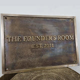 Bronze plaque with custom text on a textured surface.