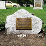Memorial stone with a bronze plaque in a cemetery