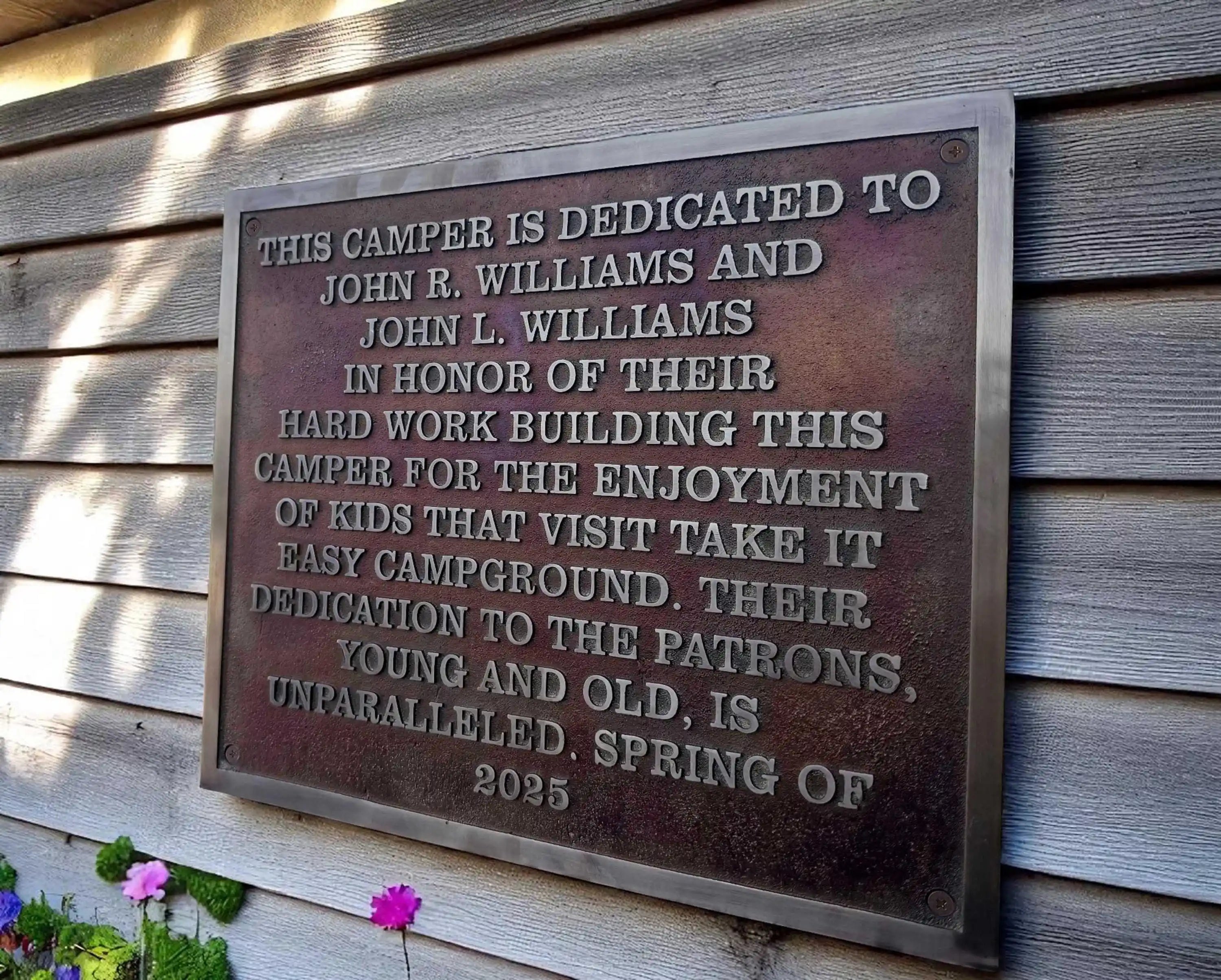 Plaque dedicated to John R. Williams and John L. Williams, honoring their contribution to a campground.