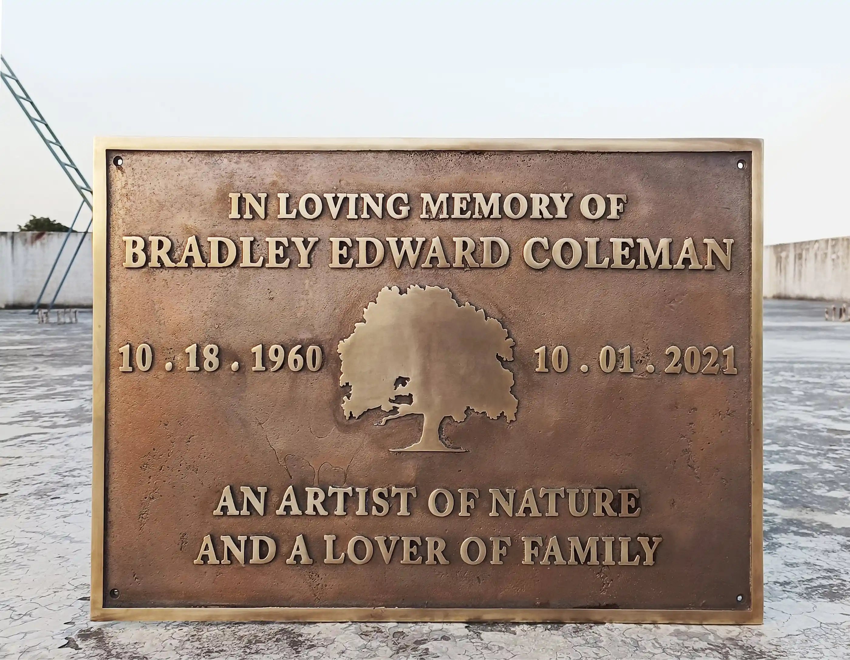 Memorial plaque for Bradley Edward Coleman with a tree design on a snowy background