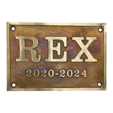 Aged bronze plaque with 'REX' and dates 2020-2024 on a white background