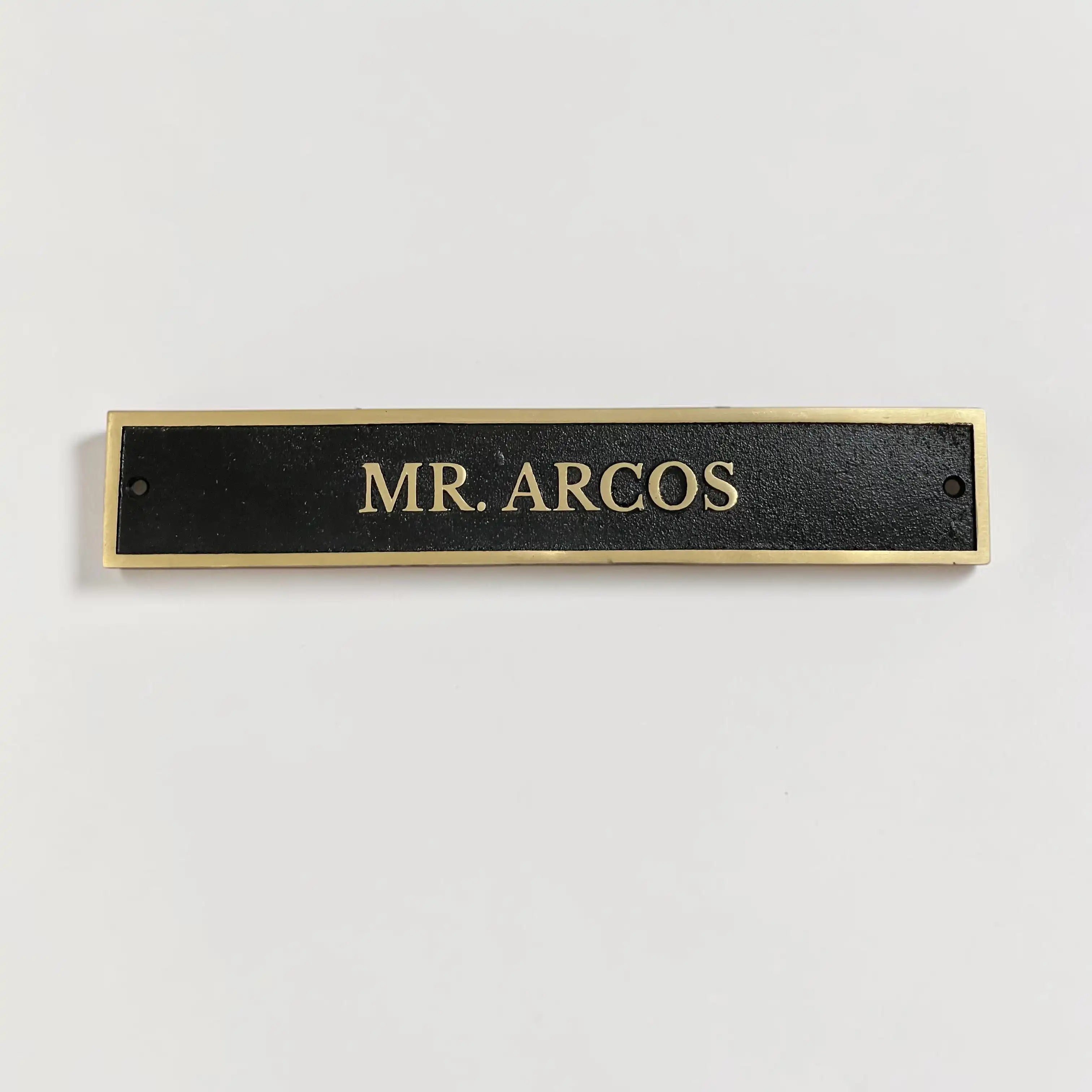 Custom engraved solid brass nameplate featuring a black oxidized background and gold-colored letters