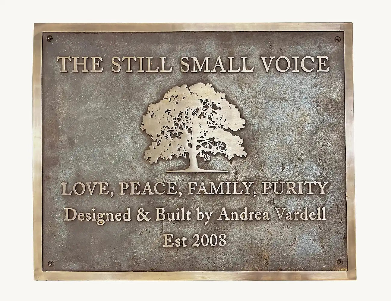Decorative plaque with tree design and text on a white background