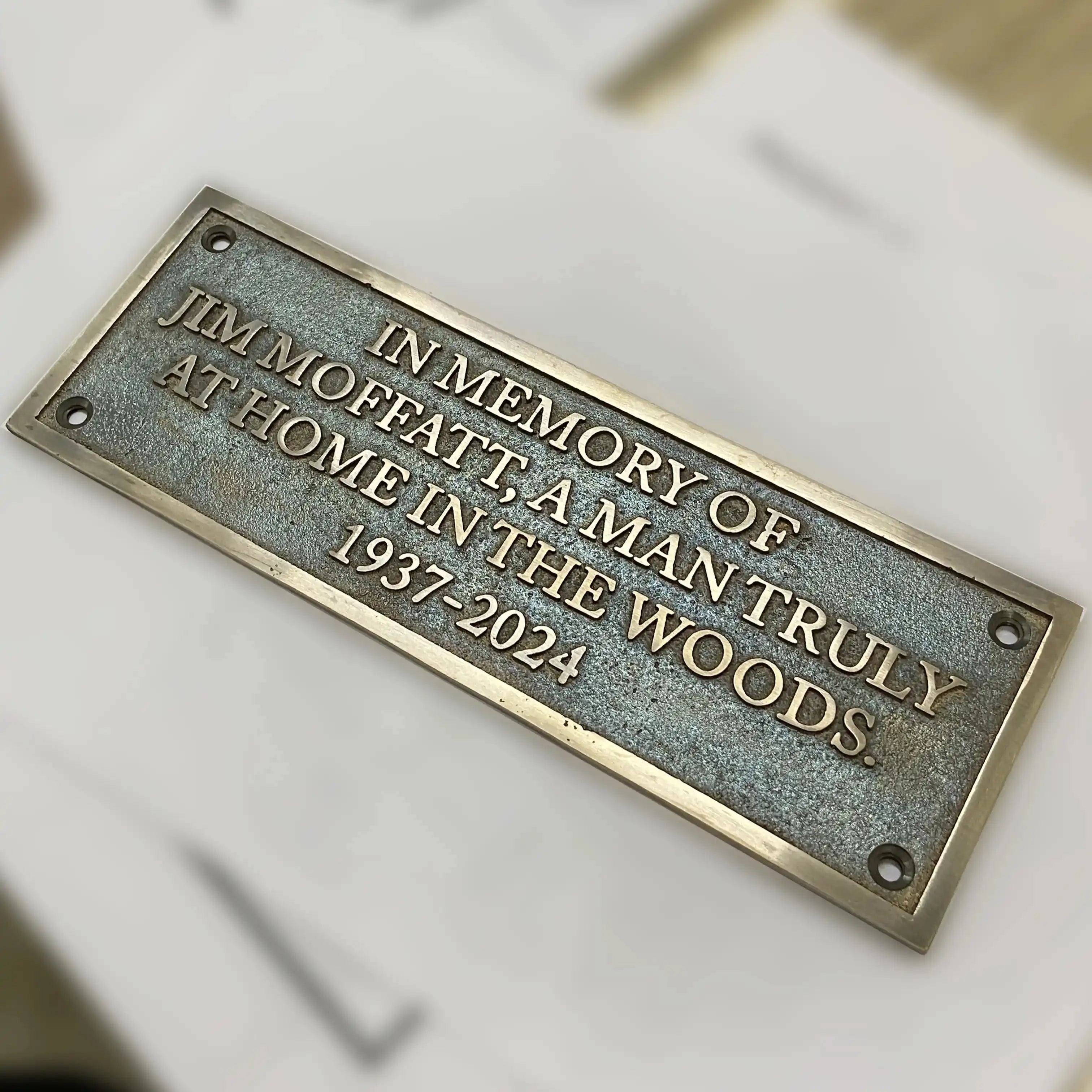 Memorial plaque for Jim Moffat on a white background