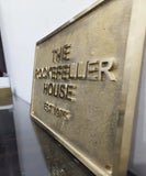 Brass plaque with 'The Rockefeller House' text on a white background