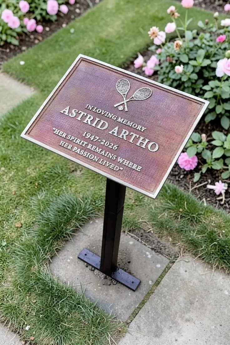 Memorial plaque for Astrid Artho in a garden setting with flowers.