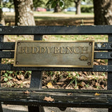 Buddy Bench with a brass plaque in a park setting