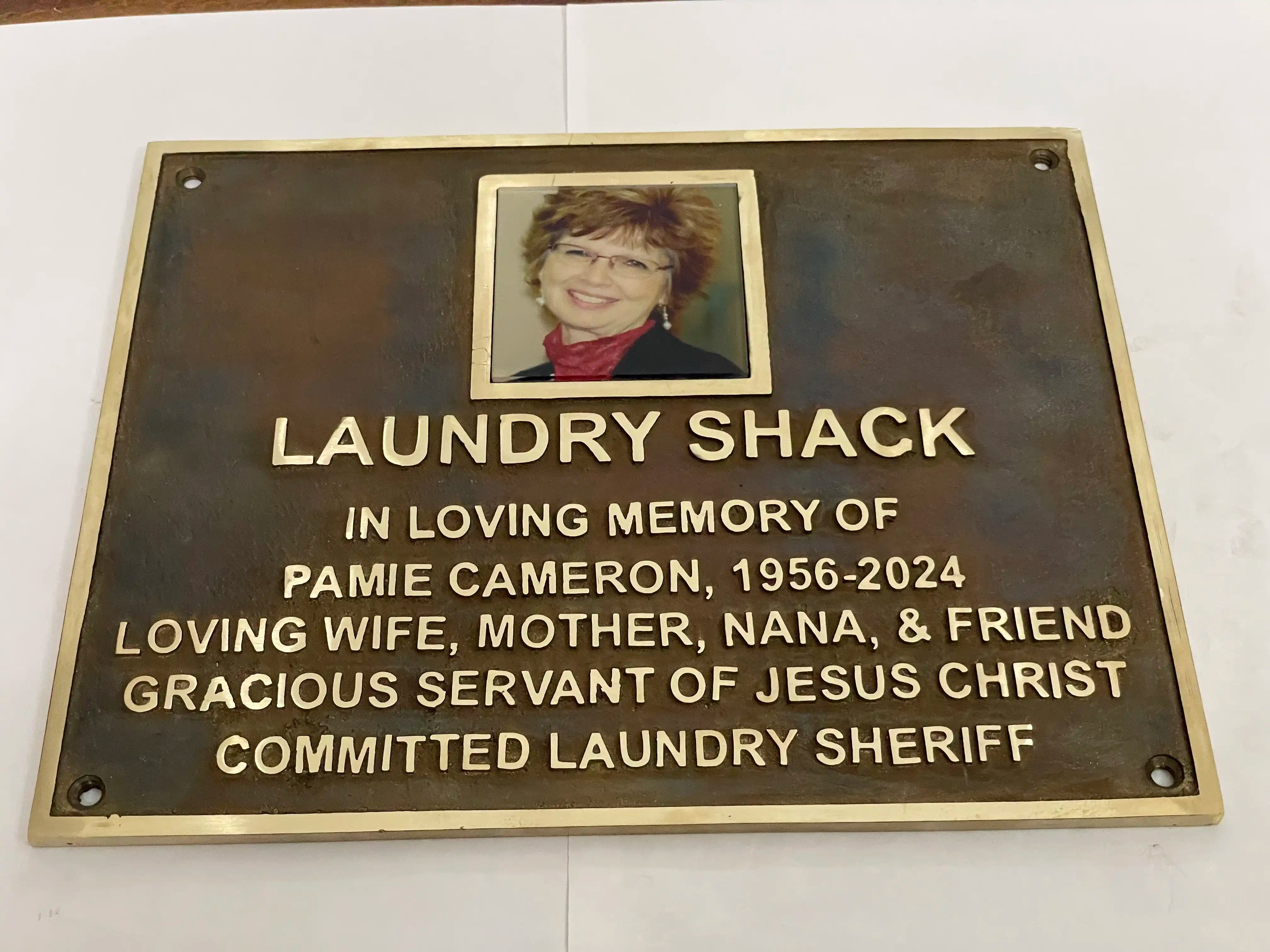 Memorial plaque for Pamie Cameron with a photo of a woman on a white background