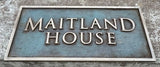 Bronze address sign with 'MAITLAND HOUSE' text on a textured background