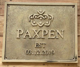 Metal plaque with 'PAXPEN' branding and establishment date on a wooden background