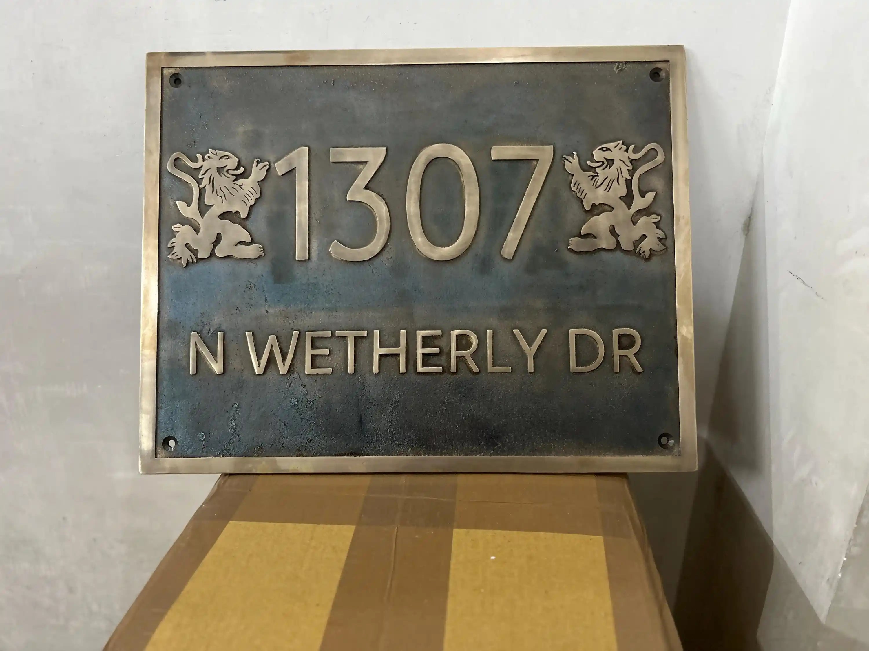 Decorative house number sign with '1307 N WETHERLY DR' on a metallic background.