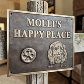 Metal sign with 'MOLLI'S HAPPY PLACE' and a dog illustration on a wooden post.