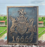 Decorative plaque with a coat of arms and number '16669' against a blurred outdoor background