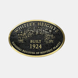 black and gold cast bronze plaque with 'Whitley Heights' text and building illustration on a white background