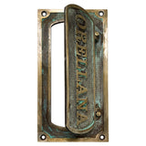 Brass mail slot for door installed on wooden front door exterior
