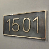 Bronze house number plaque - House number sign '1501' on a gray wall