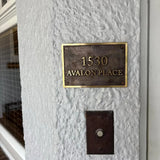 Bronze house number plaque with polished raised lettering - Address plaque on a textured wall with '1530 Avalon Place' text