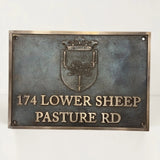 Bronze metal sign with emblem and text on a white background
