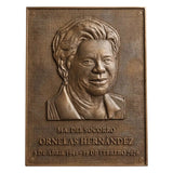 Bronze plaque with a portrait and engraved text on a white background