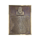 A rectangular bronze memorial plaque with a raised portrait at the top and engraved text honoring Randall 'Randy' Atkisson, shown on a plain white background.