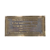 A rectangular bronze metal plaque with engraved text reading 'RICHARD SWENSON Lobo swenson, 2022 Scrap metal sculpture DONATED BY RICHARD SWENSON & VIVIEN CHEN' on a plain white background.