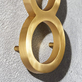 Custom solid brass building address numbers designed with a three-dimensional floating effect and concealed mounting.