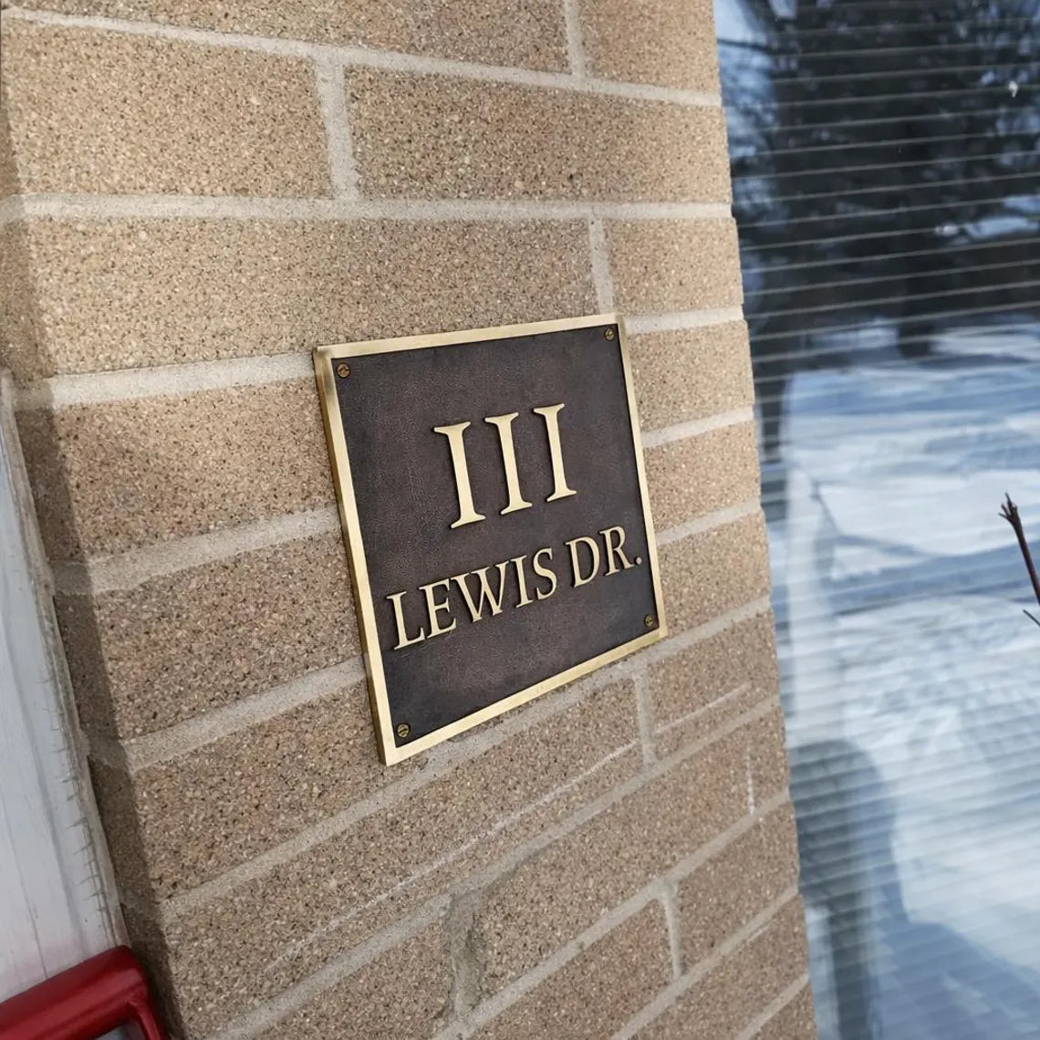 Address sign on a brick wall with 'III LEWIS DR.' text