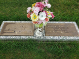 Grave markers with names Ruth Hood and William Carlos Hood, featuring a bouquet of flowers on a grassy background.