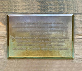 Metal plaque with engraved text on a wooden background