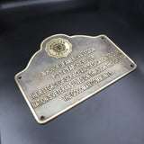 Bronze plaque honoring with engraved text on a dark background