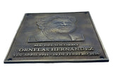 Bronze plaque with a portrait and text on a white background