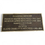 A rectangular bronze memorial plaque with engraved gold lettering, shown against a plain white background.