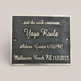 Bronze memorial plaque with engraved text on a gray background