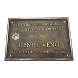 Bronze plaque with engraved text and paw print on a white background