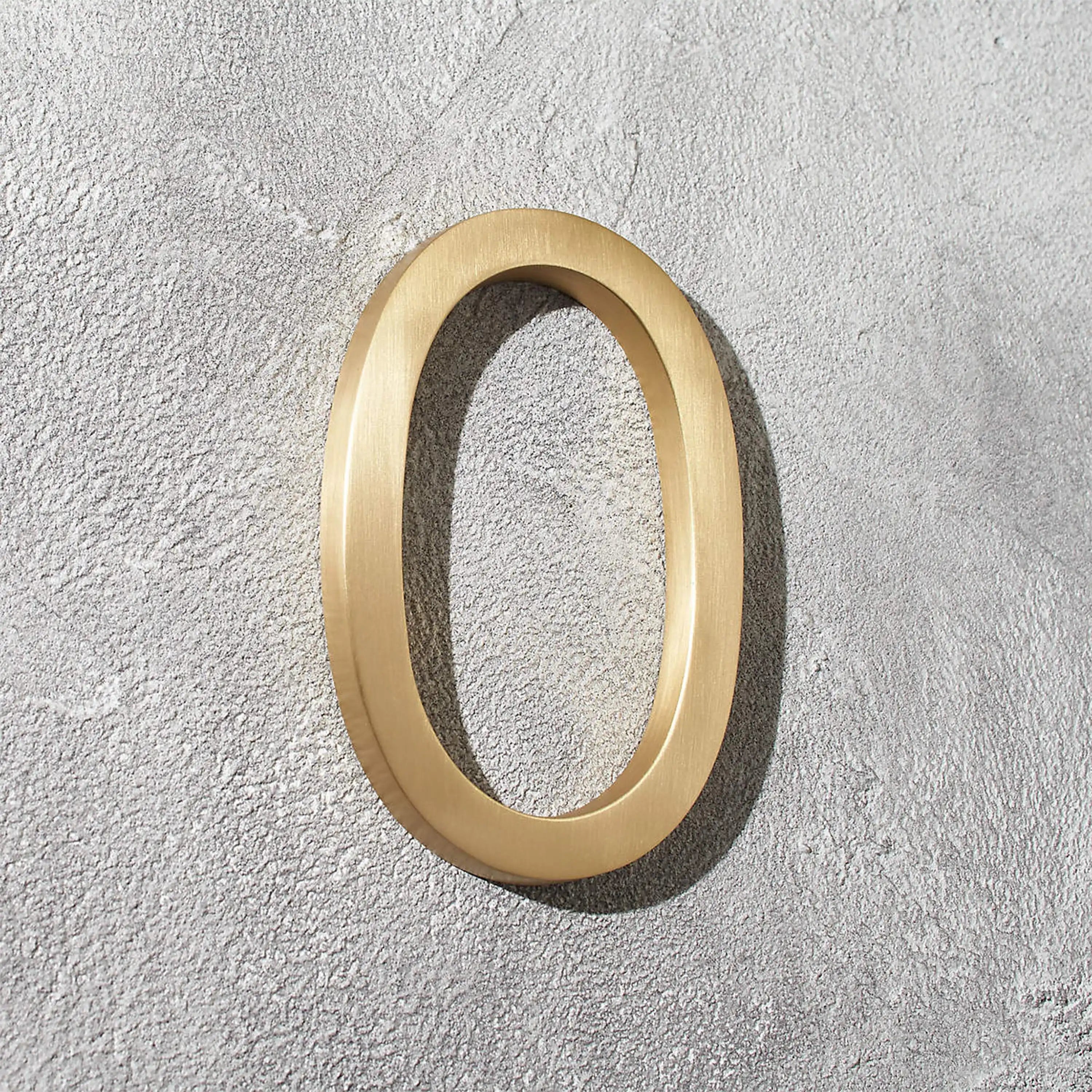 Solid brass address numbers with floating hidden stud mounting for modern home exteriors and entryways.