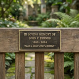Bronze Memorial plaque on a wooden bench in a garden setting