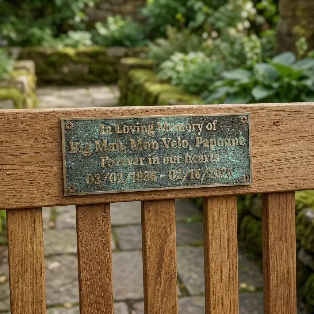 Bronze Memorial plaque in Wooden bench and plaque in memory of a pet named 'Big Man, Mon Velo, Papouné' in a garden setting.